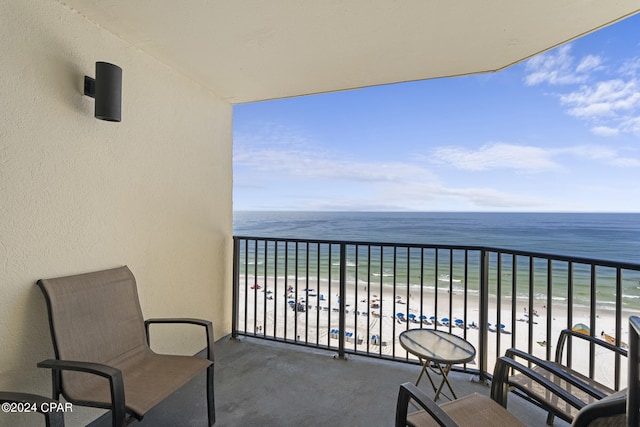 balcony featuring a view of the beach and a water view