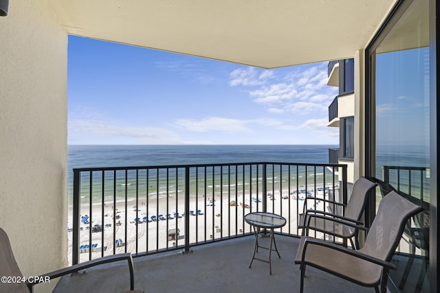 balcony featuring a water view and a beach view