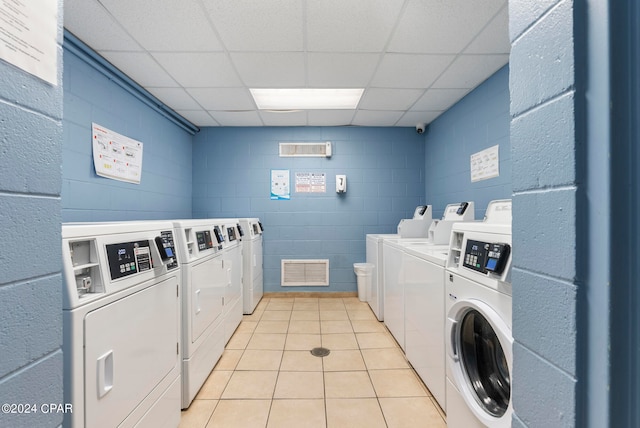 washroom with washing machine and dryer and light tile patterned flooring