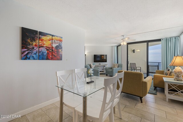 dining space with ceiling fan, a textured ceiling, and floor to ceiling windows