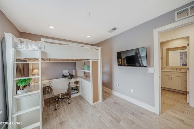 home office with sink and light hardwood / wood-style flooring