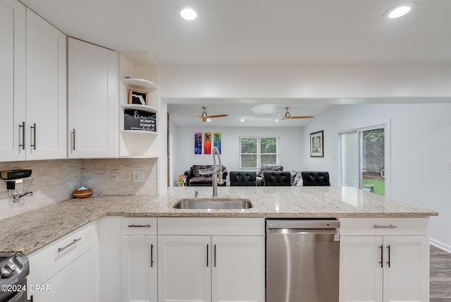 kitchen featuring kitchen peninsula, appliances with stainless steel finishes, decorative backsplash, light stone counters, and white cabinets