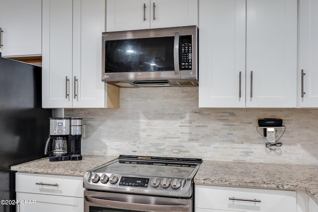 kitchen featuring decorative backsplash, light stone counters, white cabinetry, and stainless steel appliances