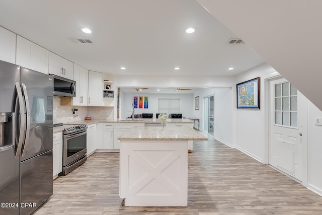 kitchen featuring light stone countertops, ceiling fan, white cabinetry, stainless steel appliances, and sink