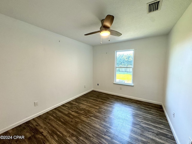 unfurnished room with ceiling fan, dark hardwood / wood-style flooring, and a textured ceiling