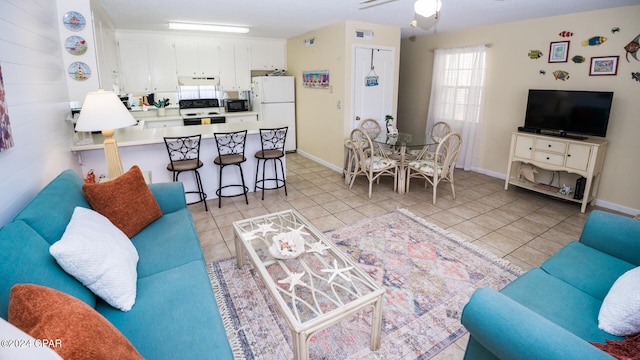 tiled living room featuring ceiling fan