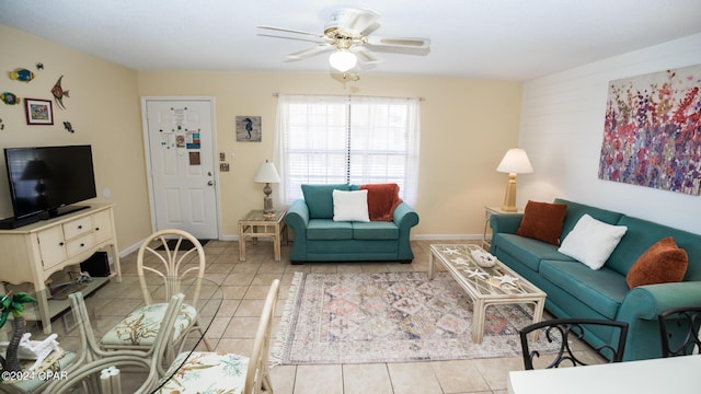 living area with baseboards, ceiling fan, and light tile patterned floors