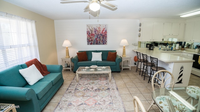 living room featuring light tile patterned floors, sink, and ceiling fan