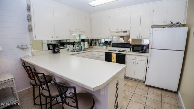 kitchen featuring white cabinets, white appliances, kitchen peninsula, and sink