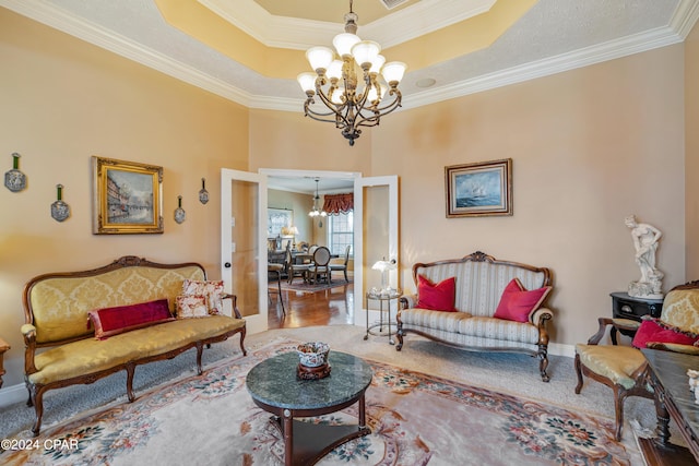 carpeted living area featuring an inviting chandelier, crown molding, baseboards, and a raised ceiling