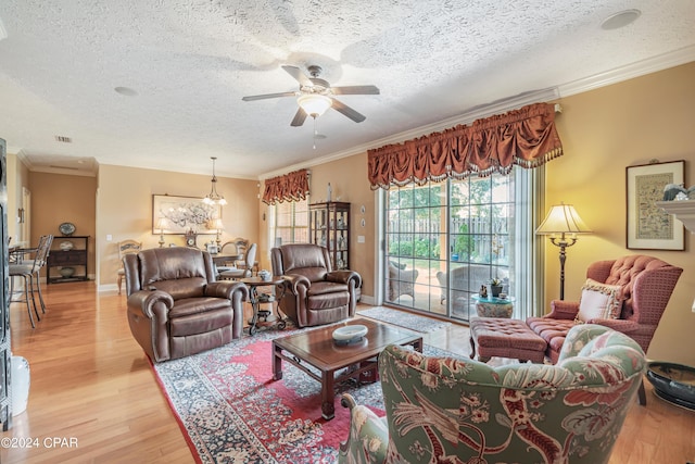 living room featuring ornamental molding, a textured ceiling, light wood finished floors, baseboards, and ceiling fan