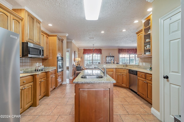 kitchen with a kitchen island with sink, a sink, a peninsula, appliances with stainless steel finishes, and glass insert cabinets