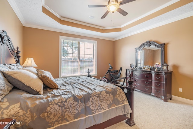 bedroom featuring a tray ceiling, light carpet, baseboards, and crown molding