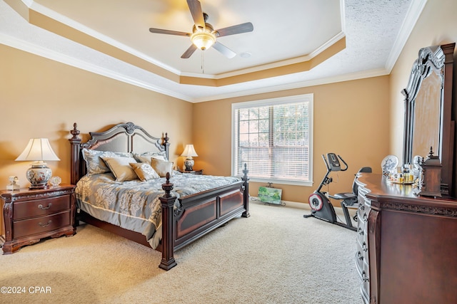 carpeted bedroom featuring a raised ceiling, a ceiling fan, baseboards, and ornamental molding