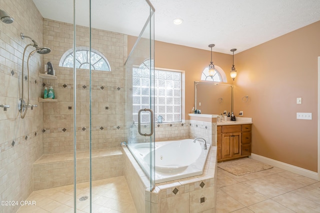 bathroom featuring tile patterned flooring, a shower stall, vanity, a garden tub, and a textured ceiling