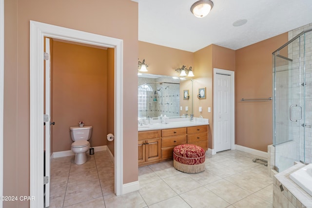 bathroom with a shower stall, toilet, double vanity, and tile patterned floors