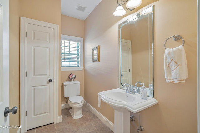 bathroom with tile patterned flooring, toilet, baseboards, and visible vents