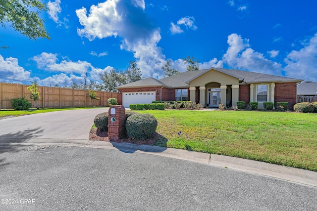 ranch-style house with brick siding, driveway, a front lawn, and fence