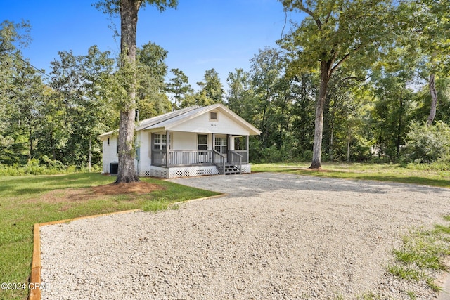 view of front of property featuring a front lawn, a porch, and central air condition unit