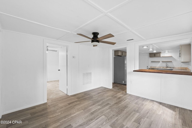 unfurnished living room with ceiling fan, coffered ceiling, and wood-type flooring