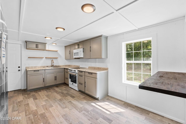 kitchen featuring sink, light hardwood / wood-style floors, white appliances, and gray cabinetry