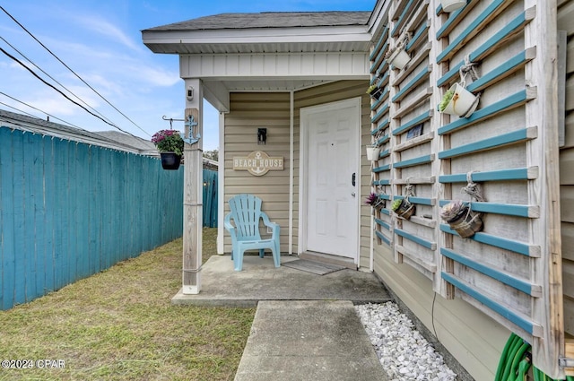 entrance to property featuring a lawn