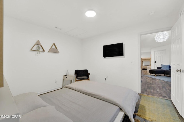 bedroom with an inviting chandelier and hardwood / wood-style flooring