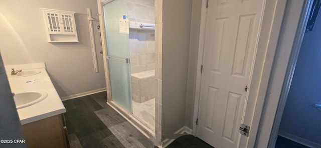 bathroom featuring hardwood / wood-style flooring, vanity, and a shower with shower door