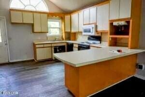 kitchen featuring lofted ceiling, kitchen peninsula, black range, cream cabinetry, and hardwood / wood-style flooring