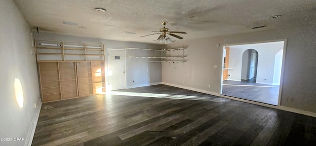 unfurnished room with ceiling fan, dark hardwood / wood-style floors, and a textured ceiling