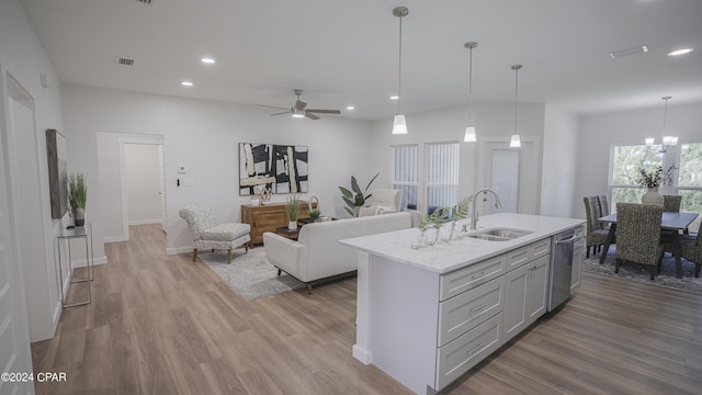 kitchen with sink, stainless steel dishwasher, decorative light fixtures, light hardwood / wood-style flooring, and ceiling fan with notable chandelier