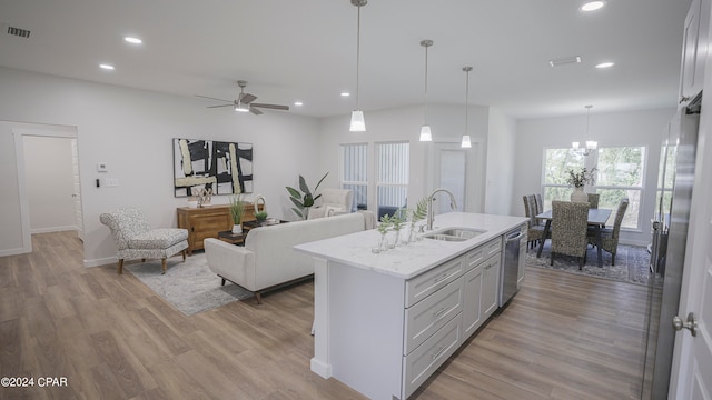 kitchen featuring ceiling fan, pendant lighting, a center island with sink, dishwasher, and light hardwood / wood-style floors