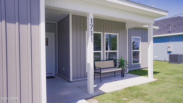 view of exterior entry with a lawn and central air condition unit