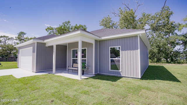 back of house featuring a yard, a porch, and a garage