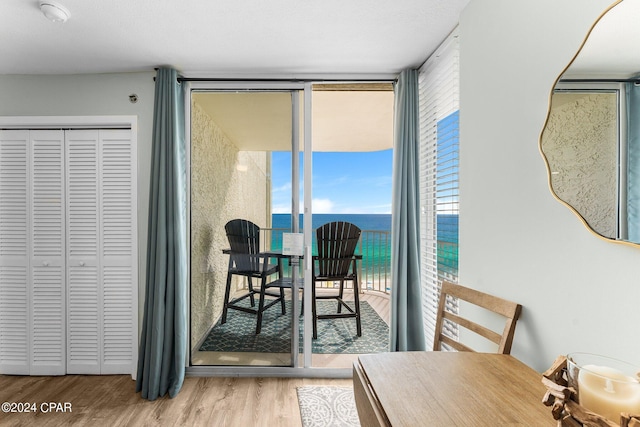 dining room featuring hardwood / wood-style flooring, floor to ceiling windows, and a water view