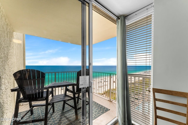 balcony featuring a water view and a beach view