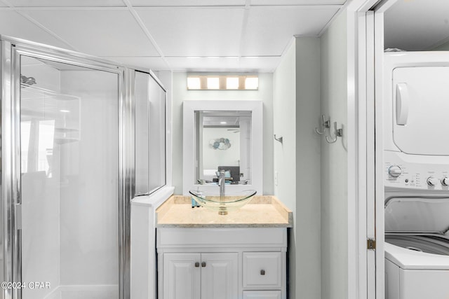 bathroom featuring vanity, stacked washer and dryer, and an enclosed shower