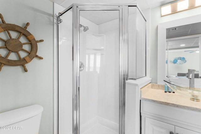 bathroom with walk in shower, vanity, toilet, and ceiling fan