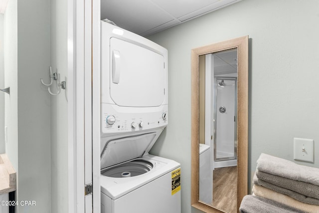 laundry area featuring hardwood / wood-style flooring and stacked washer / dryer