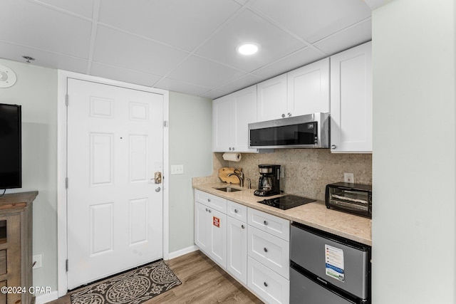 kitchen with white cabinets, stainless steel appliances, light wood-type flooring, and sink