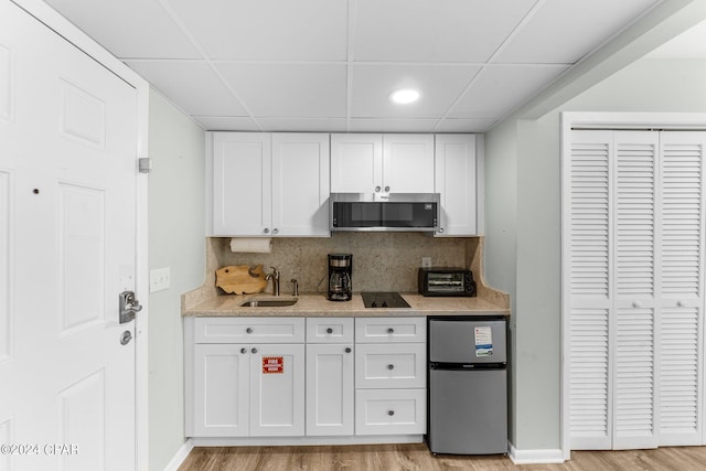 kitchen featuring light hardwood / wood-style flooring, appliances with stainless steel finishes, and white cabinetry