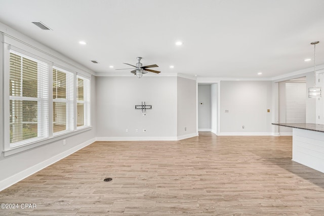 unfurnished living room with crown molding, ceiling fan, and light hardwood / wood-style floors