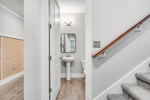 staircase featuring sink and hardwood / wood-style floors