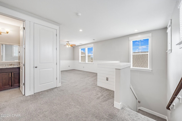 carpeted empty room with sink and ceiling fan