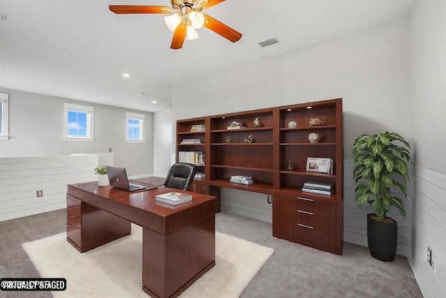 carpeted home office with ceiling fan