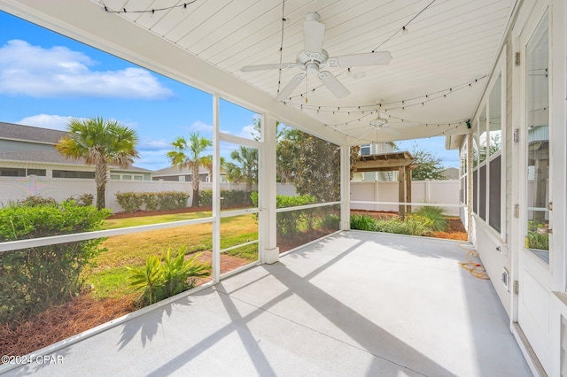 unfurnished sunroom with ceiling fan