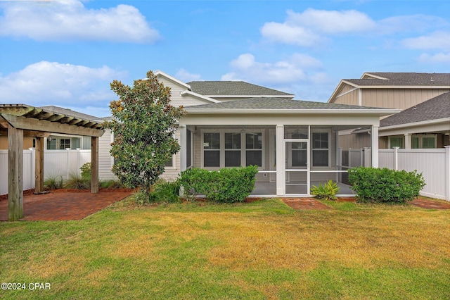 back of property with a patio, a yard, and a sunroom