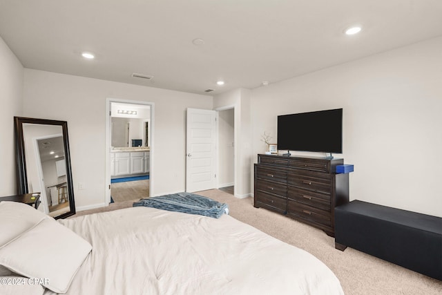 bedroom featuring light colored carpet and ensuite bathroom