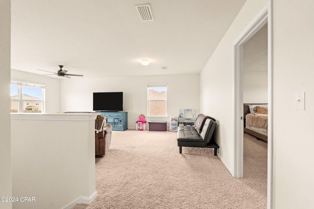 living area with ceiling fan and carpet flooring