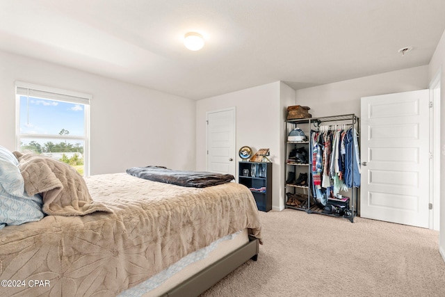 bedroom featuring light colored carpet and a closet